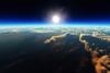 Sunrise over cloudy ocean from outer space