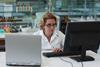 A photograph of a woman working on a computer in an organic chemistry laboratory