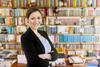 A photograph of a young professor in front of a bookcase