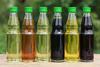 A photograph of different types of cooking oil in small bottles on a wooden table