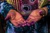 A Bandari woman showing her hands with indigo traces after sewing a traditional burqa mask