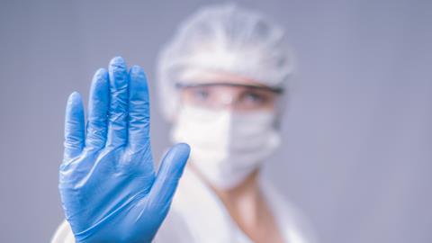 Researcher wearing lab PPE including gloves, eye protection and mask