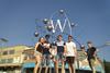 An image showing a group of students in front of a sculpture representing a tungsten atom