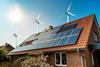 A photograph showing solar panels on a house and wind turbines