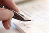 Picture of a a person holding a pen in their hand ready to write a cheque