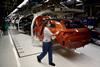 An image showing an employee wearing a face mask works on the production line at the Volkswagen Autoeuropa car factory