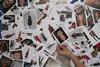 A photo of a hand choosing a photo from a pile of portraits