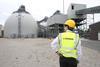 A man in a hard had standing outside an industrial plant