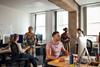 An office full of people collaborating or working on computers