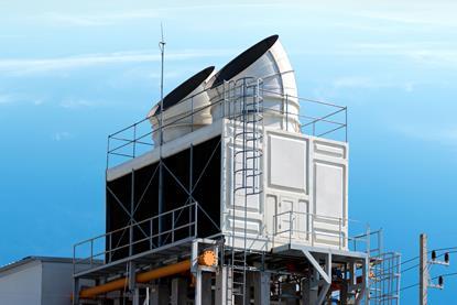 Two large open ended pipes emerging from a large industrial white box of a carbon capture system