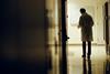 Rear view of a man in a lab coat on an empty corridor